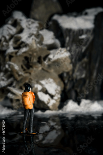 person miniature climbing a rock