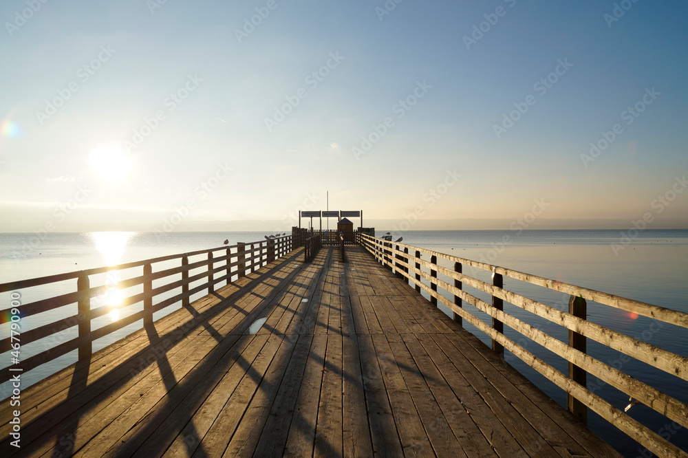 a long wooden pier in Herrsching on Lake Ammersee in Bavaria on a clear and sunny December evening (Germany)