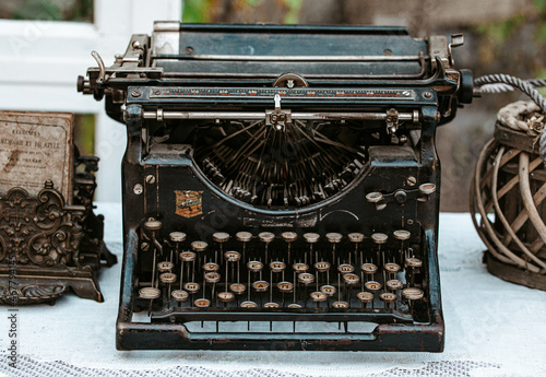 Close-up of Vintage old fashioned typewriter machine Underwood on desk next to window in light white shabby chic vintage country cottage interior room
 photo