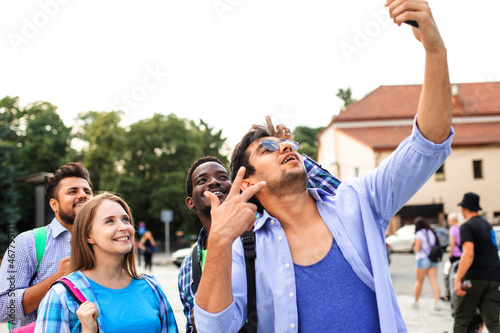 The joyful group of multiethnic students taking a selfie outdoors