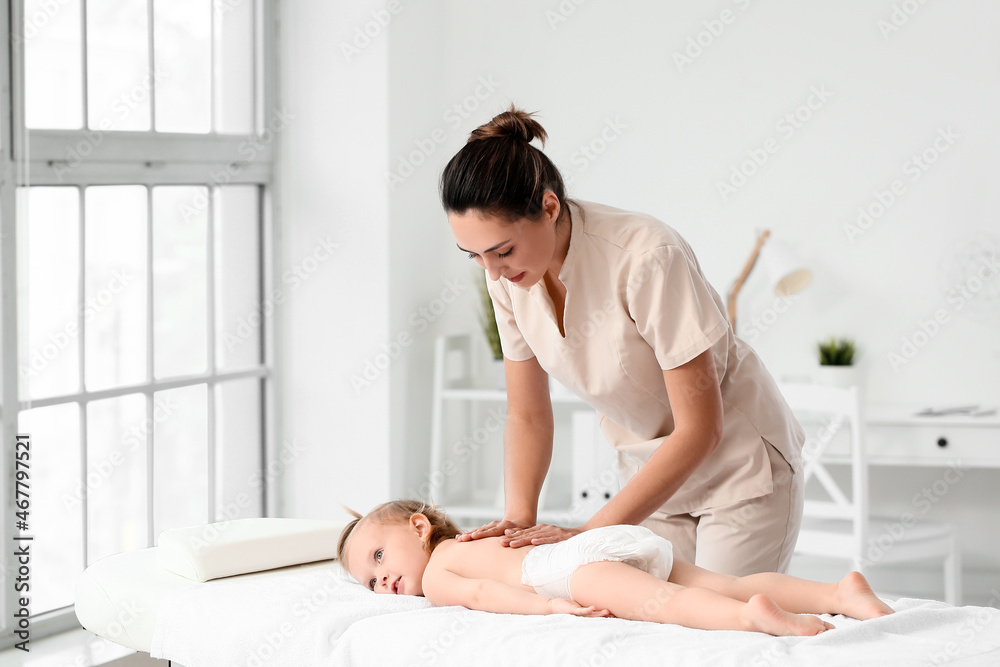 Massage therapist working with baby in medical center