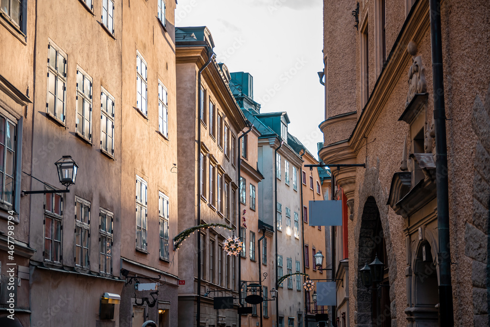 Narrow streets with New Year's, Christmas decorations, festive garlands and stars on the facades of old houses on the streets in Gamla Stan, Stockholm, Sweden