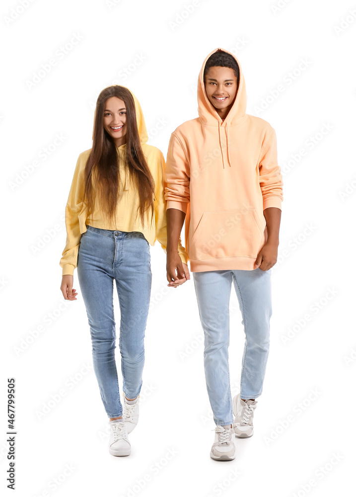 Stylish young couple in hoodies holding hands on white background