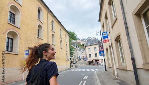A panoramic shot of a cheerful lady from Luxembourg dressed casually walking in a luxembourg city