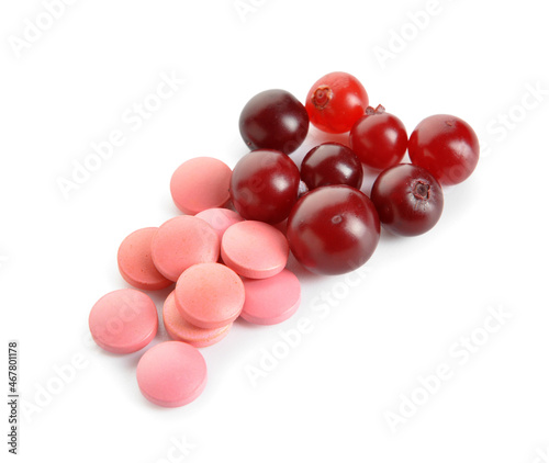 Cranberry pills and berries on white background