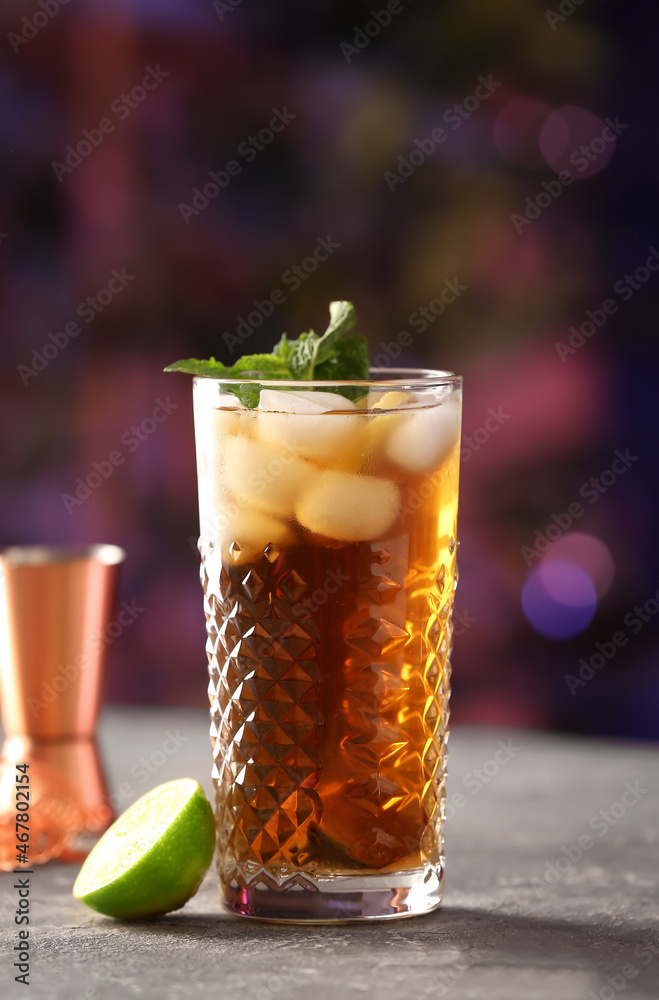 Glass of tasty Cuba Libre cocktail with mint on table in bar Glass of tasty Cuba Libre cocktail with mint on table in bar