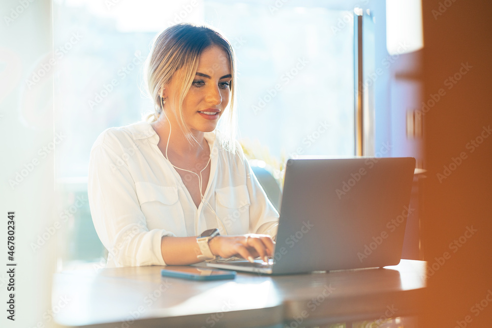 Content businesswoman typing on laptop in cafe Content businesswoman typing on laptop in cafe