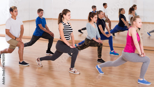 Fototapeta Naklejka Na Ścianę i Meble -  happy germany teenage boys and girls with trainer stretching in dance hall