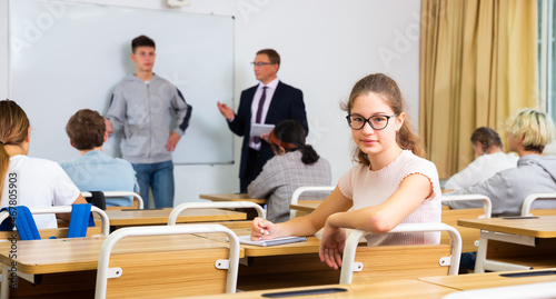 Portrait of girl who is posing at the desk in the class