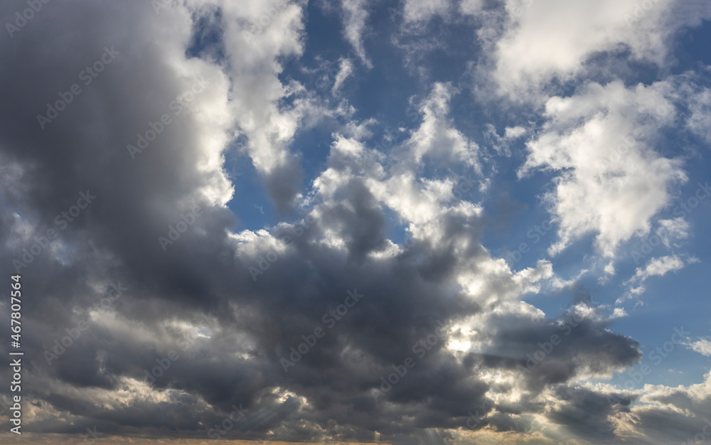Sunlight through the clouds. Beautiful clouds in the blue sky. Evening autumn sky. Sunlight through the clouds. Beautiful clouds in the blue sky. Evening autumn sky.
