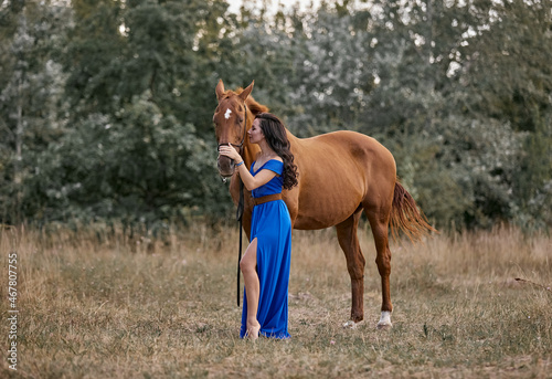 Beautiful long-haired girl in a blue dress with a red horse © Елизавета Мяловская