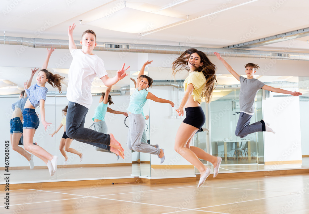 Group of cheerful tweens jumping during modern dances class