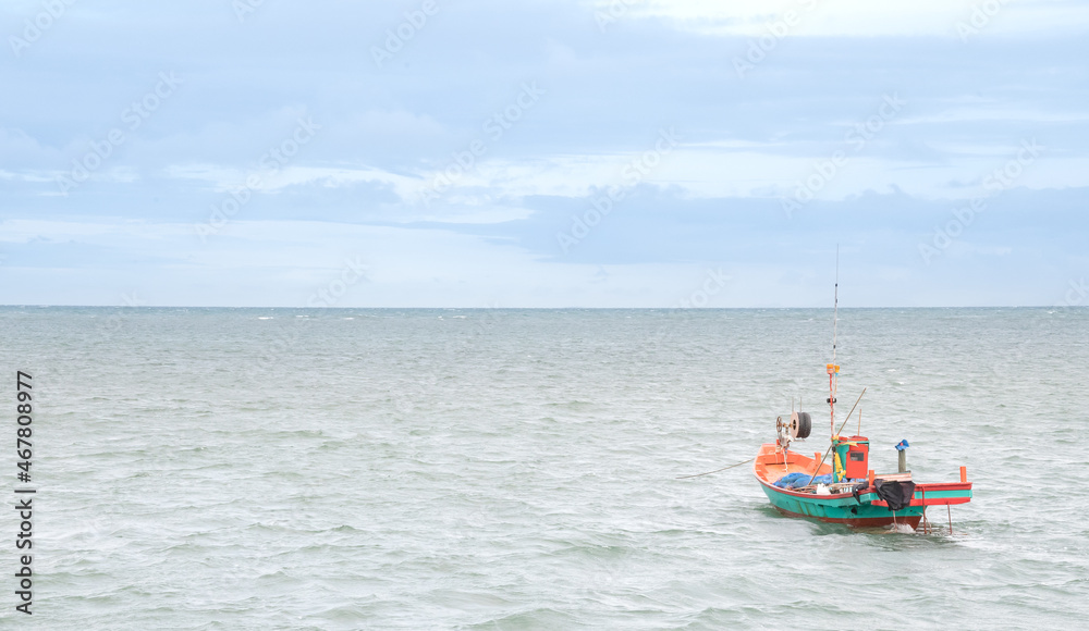 The small fisherman boat floating on the sea waiting for catching the fish and preparing to sell at the seafood market on the shore. The small fisherman boat floating on the sea waiting for catching the fish and preparing to sell at the seafood market on the shore.