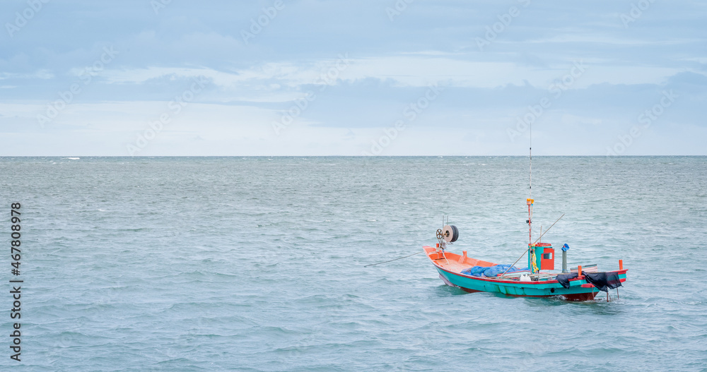 The small fisherman boat floating on the sea waiting for catching the fish and preparing to sell at the seafood market on the shore. The small fisherman boat floating on the sea waiting for catching the fish and preparing to sell at the seafood market on the shore.