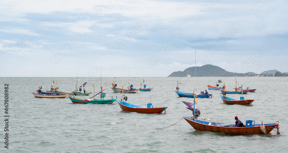The small group of fisherman boat floating on the sea waiting for catching the fish and preparing to sell at the seafood market on the shore