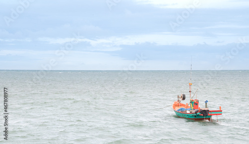 The small fisherman boat floating on the sea waiting for catching the fish and preparing to sell at the seafood market on the shore.