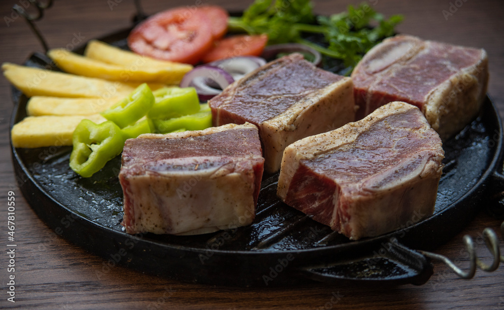 BEEF CUT INTO PIECES, WITH VEGETABLES SUCH AS TOMATO, ONION, PARSLEY, PEPPERS AND POTATOES, ON GRILL, READY TO BRING TO THE FIRE BEEF CUT INTO PIECES, WITH VEGETABLES SUCH AS TOMATO, ONION, PARSLEY, PEPPERS AND POTATOES, ON GRILL, READY TO BRING TO THE FIRE