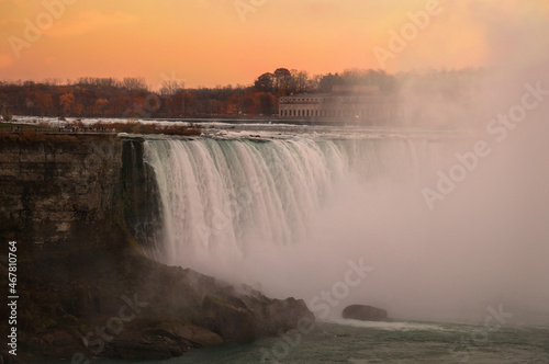 Sunset view of Horseshoe Falls waterfall in front of spectacular sunset sky. It is the largest of three Niagara Falls waterfalls on the Niagara River along the Canada - U.S. border. 
