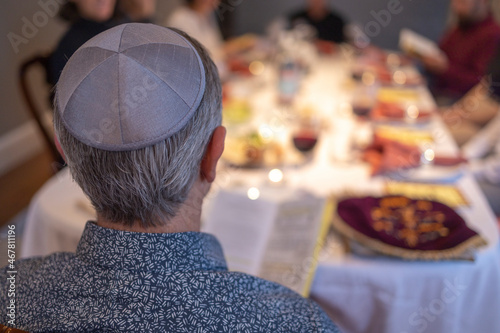 Jewish man leading the Passover seder wearing a yarmulkeh photo