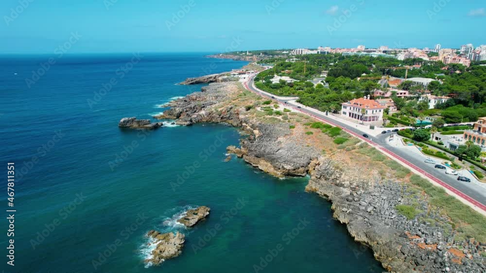 Aerial drone view of the rocky shore and Cascais coastal road, in sunny Portugal Aerial drone view of the rocky shore and Cascais coastal road, in sunny Portugal