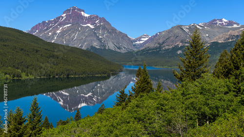 Rising Wolf Mountain - A Spring morning view of towering Rising Wolf Mountain reflecting in calm Lower Two Medicine Lake. Glacier National Park, Montana, USA. photo