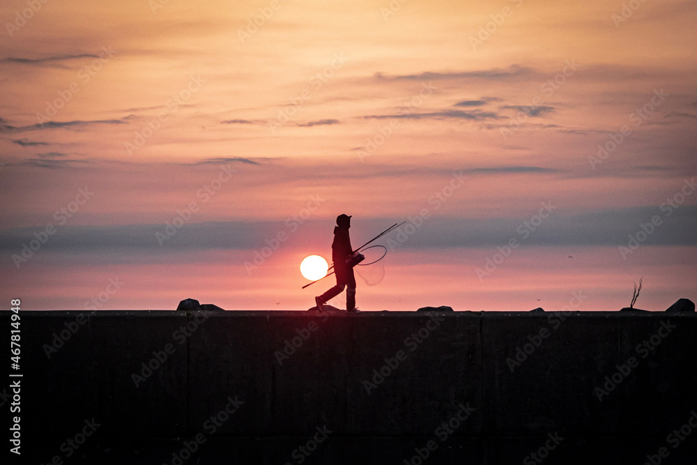 Fototapeta premium 朝日に照らされる釣り人