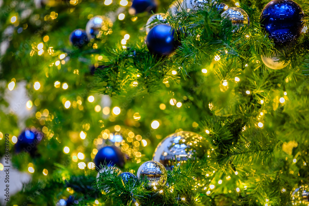 Warm green with blue and silver reflective Christmas ornaments across the top and bottom in a tree