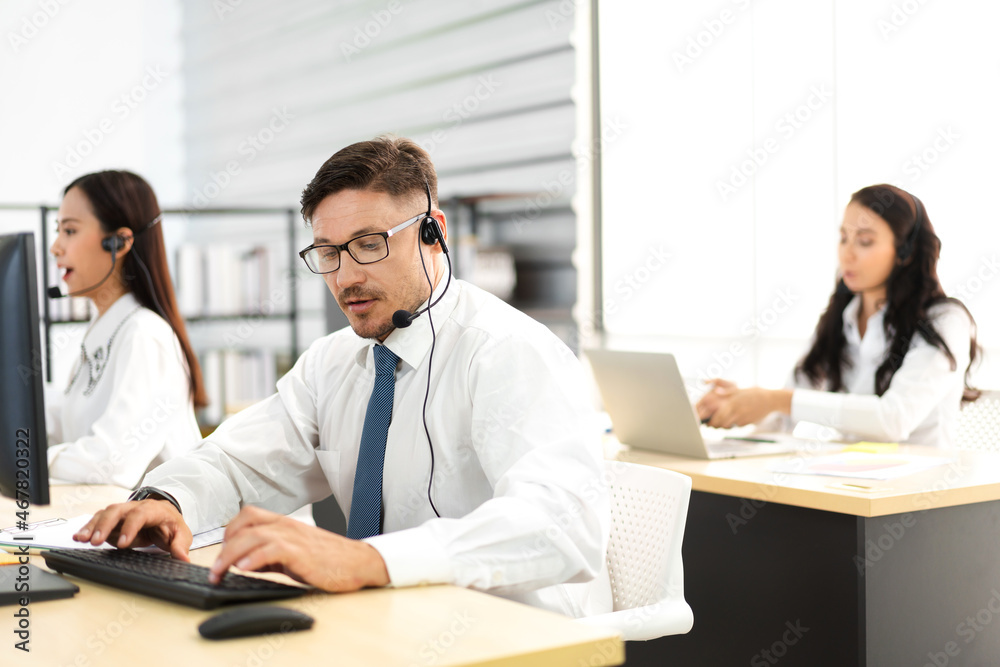 Group of happy call center smiling business operator customer support team phone services agen working and talking with headset on desktop computer at call center Group of happy call center smiling business operator customer support team phone services agen working and talking with headset on desktop computer at call center