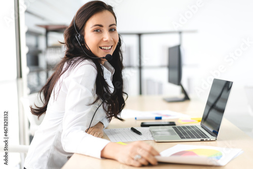 Beautiful happy call center smiling businesswoman operator customer support consult phone services agen working with wireless headset microphone and computer at call center office