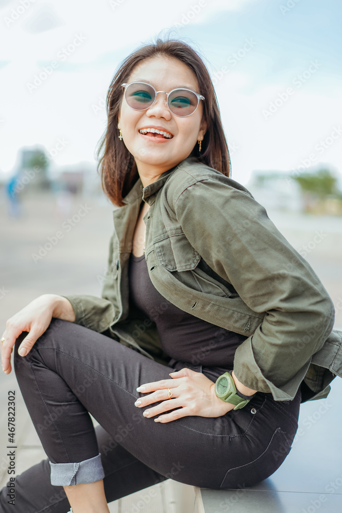 Young Beautiful Asian Woman Wearing Jacket And Black Jeans Posing Outdoors