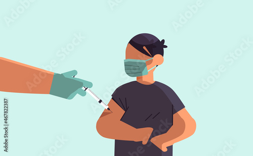 doctor hand vaccinating boy patient in medical mask fight against coronavirus vaccine development concept