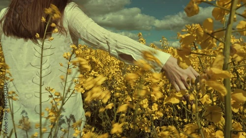 Happy beautiful young woman in rapeseed flowers field. Woman freedom. Woman power. Women rights.