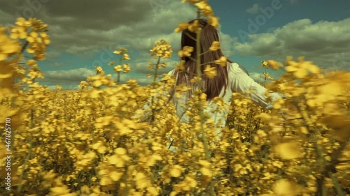 Happy beautiful young woman in rapeseed flowers field. Woman freedom. Woman power. Women rights.
