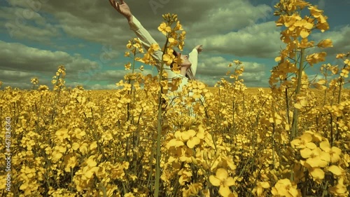 Happy beautiful young woman in rapeseed flowers field. Woman freedom. Woman power. Women rights.