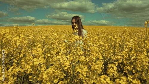Happy beautiful young woman in rapeseed flowers field. Woman freedom. Woman power. Women rights.