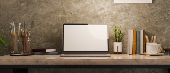 Laptop computer blank screen mockup on vintage marble table with colouring tools and decor.