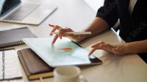 Businesswoman using tablet, fingers tapping, touching on a modern digital tablet screen