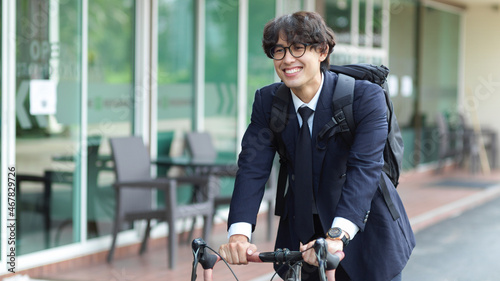 Successful young businessman executive commuting by bike to his company.