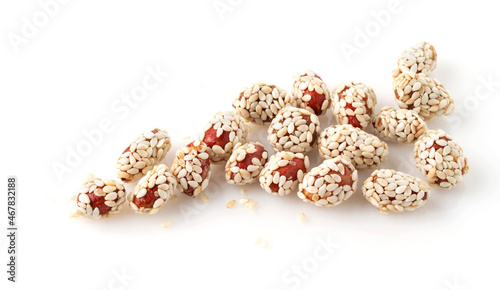 peanut grains in caramelized sesame seeds on white plate