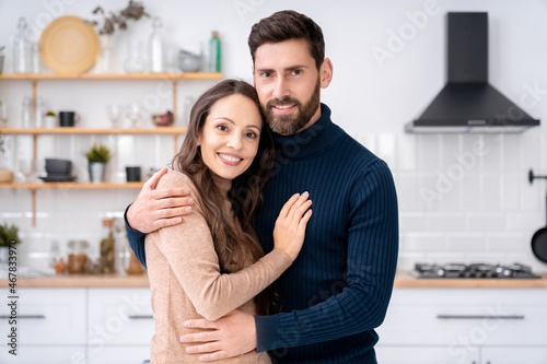 Loving wife and husband hugging looking at camera standing together at home © Stock 4 You