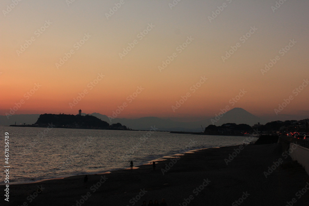 夕暮れの湘南の海。オレンジ色に染まる空と、江の島そして富士山。