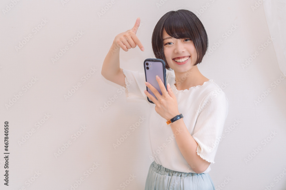 スマホを指さして楽しそうな女性 スマホを指さして楽しそうな女性