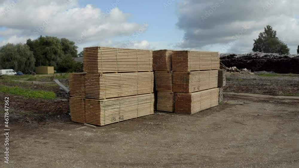 Stack of wood planks. Drone increasing hight, panning down. Birds flying around drone.