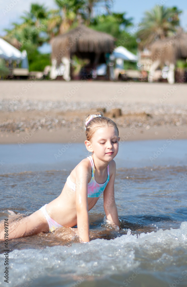 Little girl playing on the beach by the sea Little girl playing on the beach by the sea