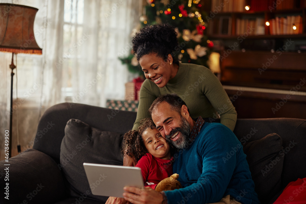 Family gathered on sofa, using a tablet Family gathered on sofa, using a tablet