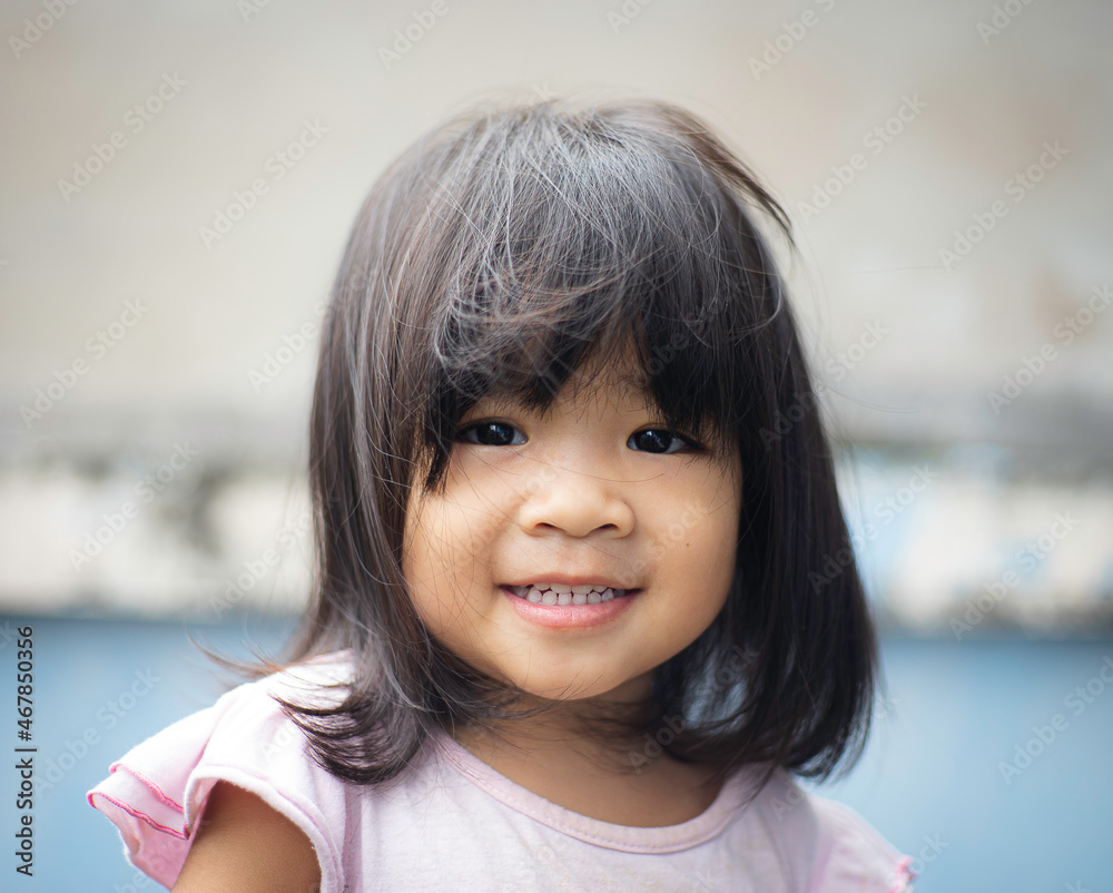 A headshot portrait of a cheerful baby Asian woman, a cute toddler little girl with adorable bangs hair, a child wearing a blue sweater smiling and looking to the camera. A headshot portrait of a cheerful baby Asian woman, a cute toddler little girl with adorable bangs hair, a child wearing a blue sweater smiling and looking to the camera.