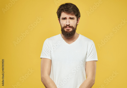emotional man in a white t-shirt expressive look discontent Studio