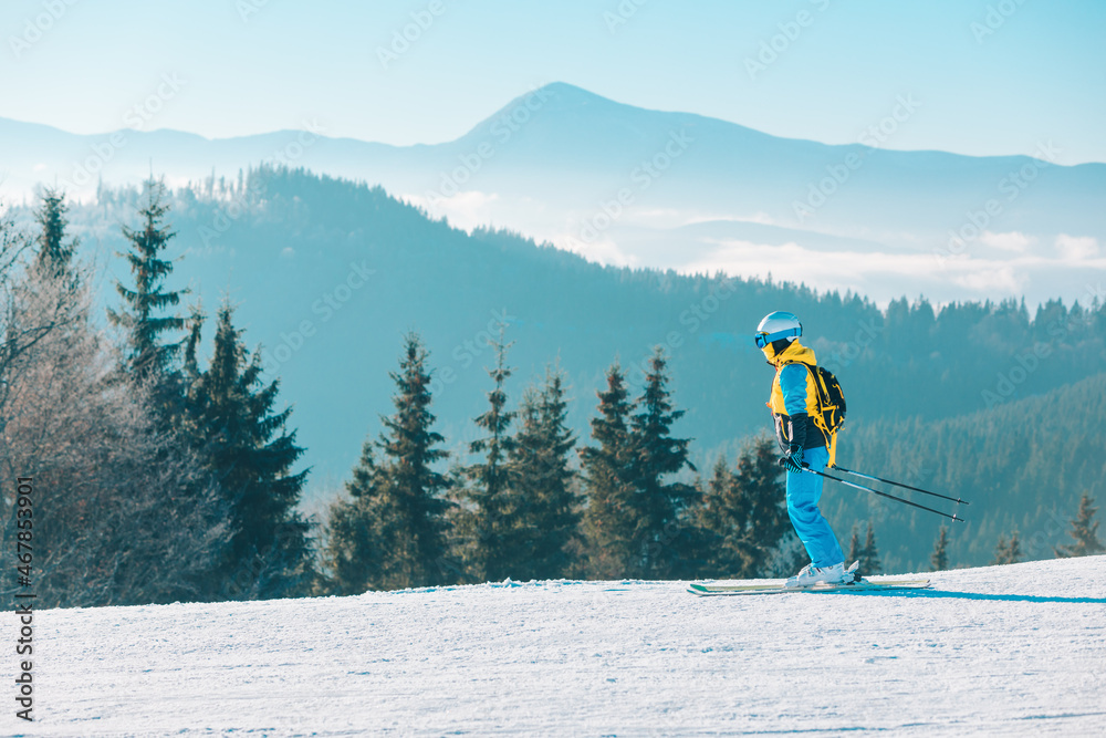 woman skiing down by winter slope