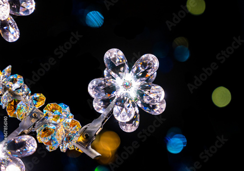 detail of a crystal chandelier on black background with bokeh effect © Geert