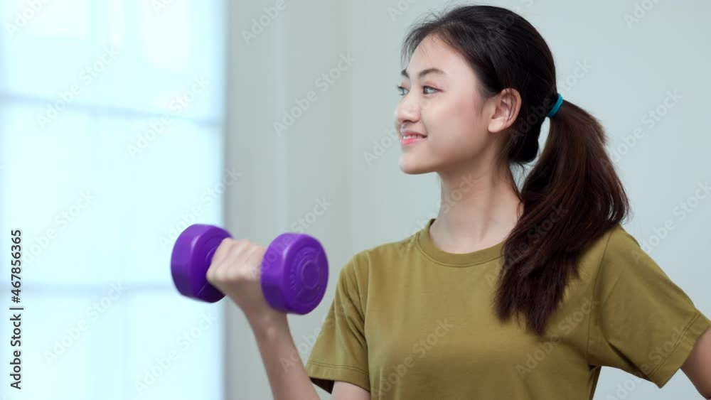 Attractive asian young fitness woman lifting dumbbell weights workout at home in living room. Fresh feeling female training and exercise wearing sport wear fit body. Attractive asian young fitness woman lifting dumbbell weights workout at home in living room. Fresh feeling female training and exercise wearing sport wear fit body.